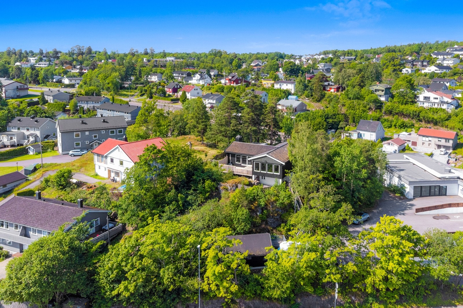 I forkant og på nedsiden av huset finner vi en dobbel garasje med bod Galleribilde