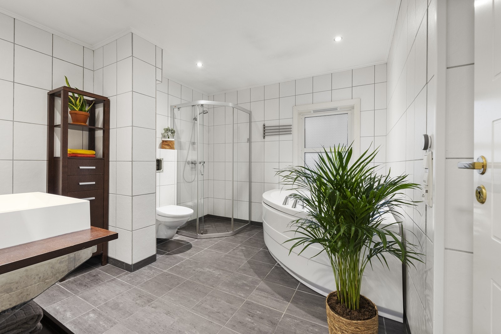 Det flislagte badet i andre etasje er utstyrt med både dusjsone og badekar. Galleribilde