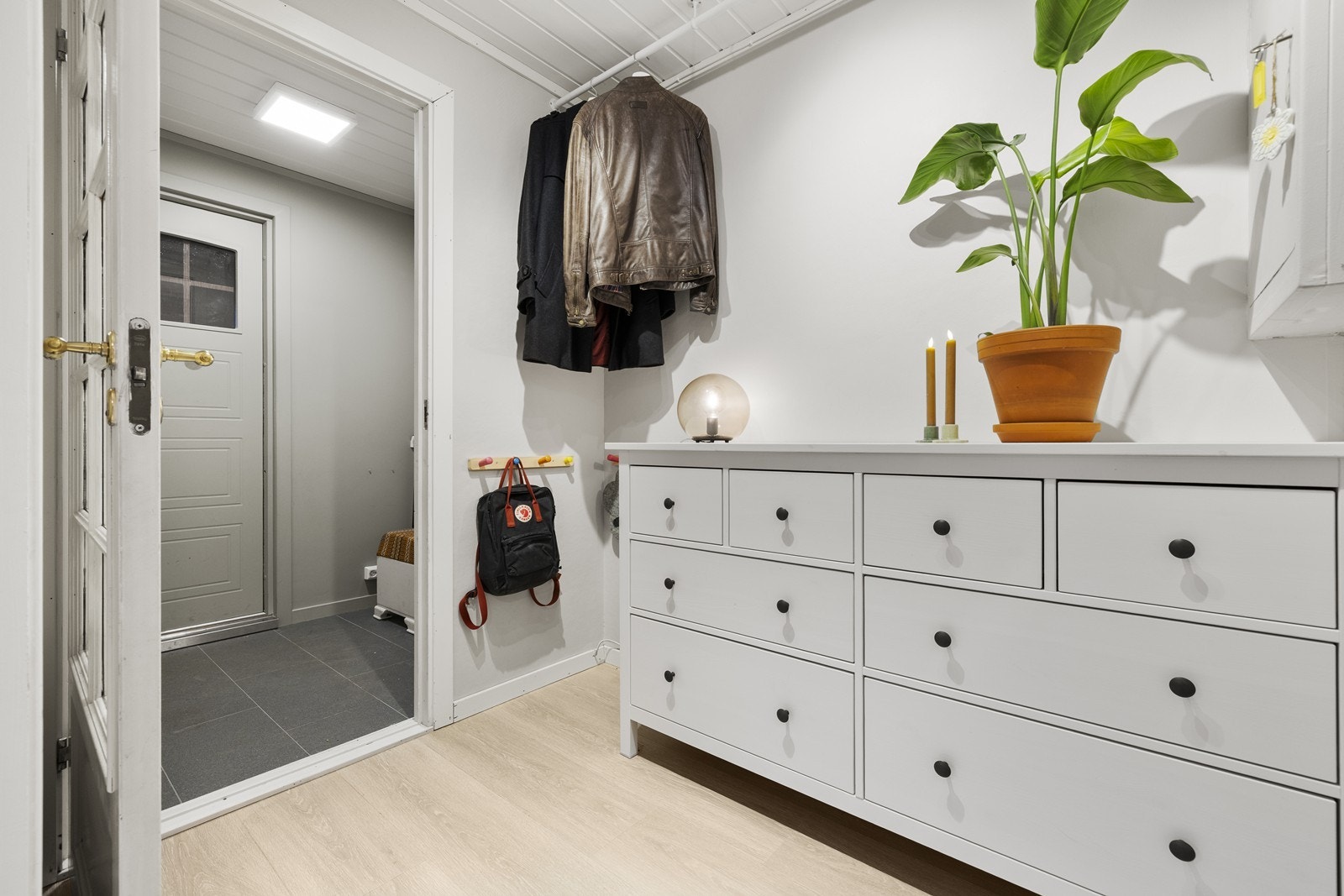 Velkommen inn til en innbydende entré! I yttergangen er det fliser med varmekabler, mens i innergangen er det laminat med varmefolie. Galleribilde