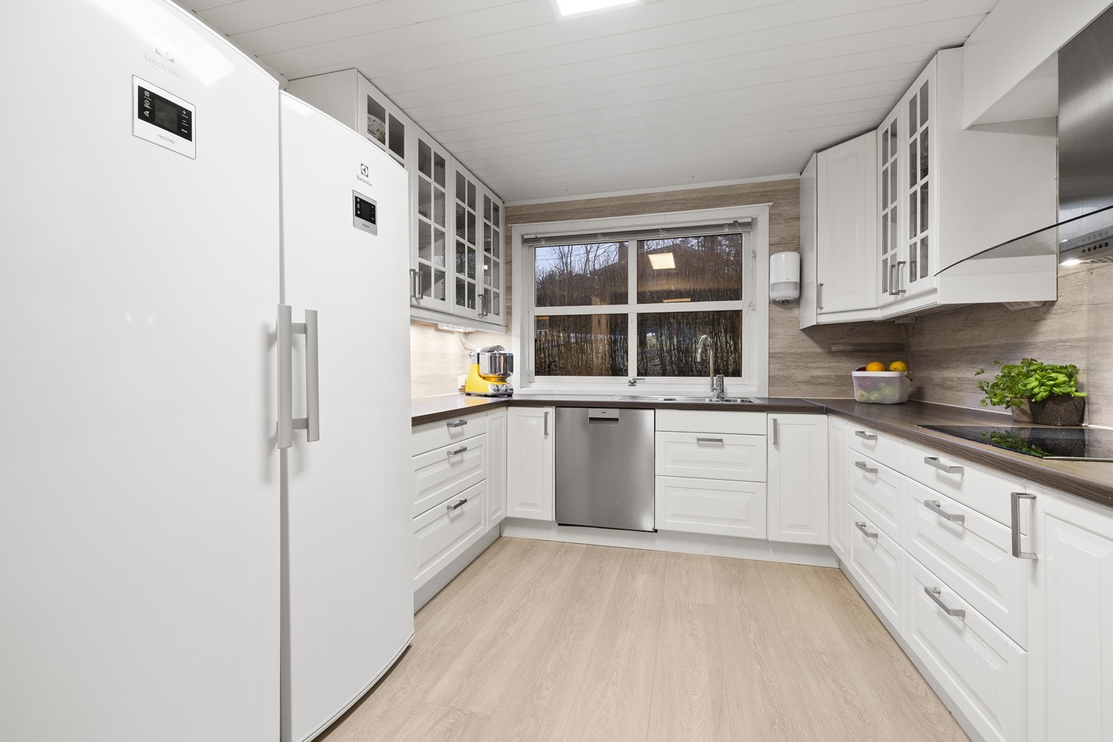 Lyst kjøkken med rikelig skap- og benkeplass. Galleribilde