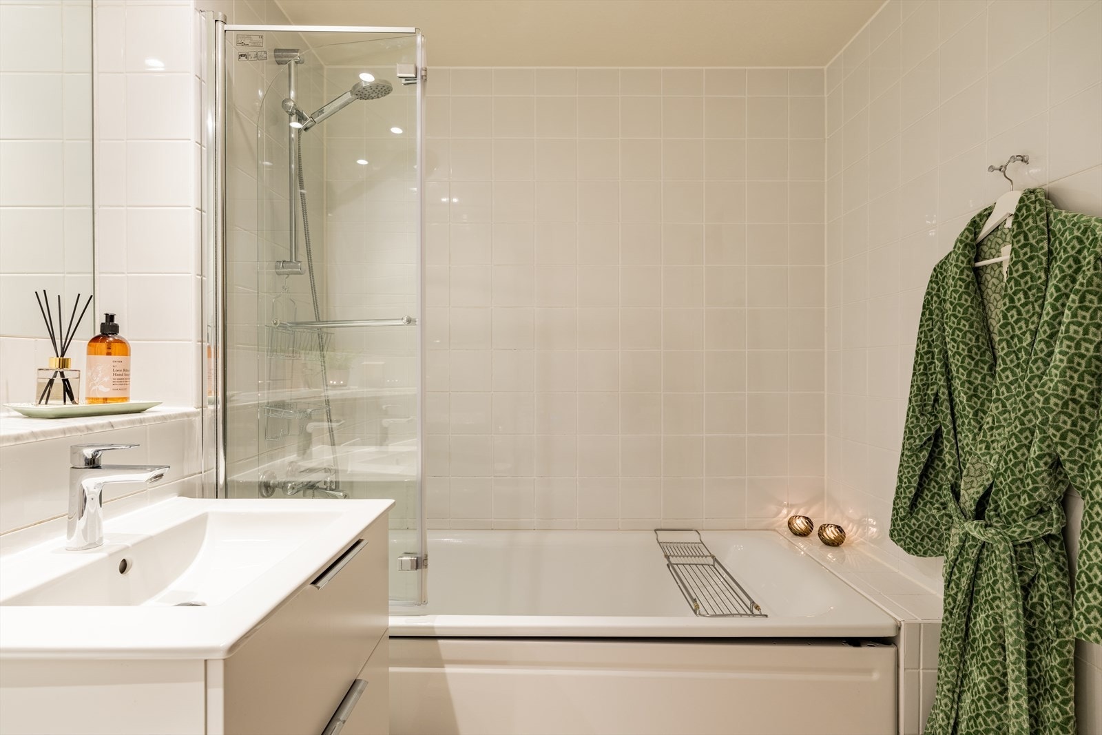 Videre består badet av dusj i badekar med innfellbar dør i herdet glass, servant i helstøpt plate og veggfestet klosett med innebygget sisterne Galleribilde