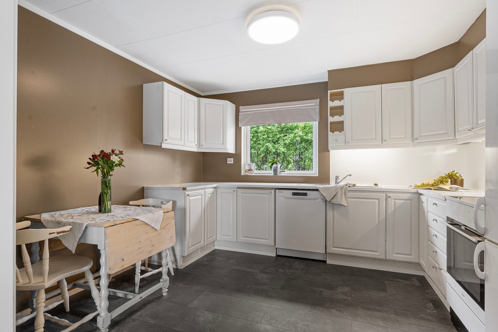 Lyst og åpent kjøkken med god skap- og benkeplass Galleribilde