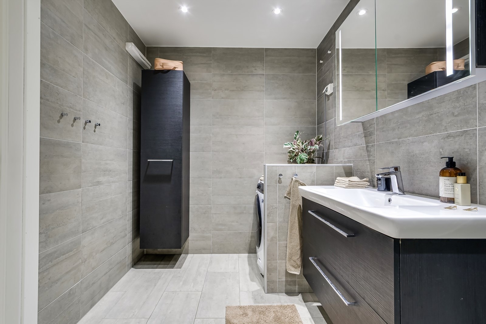 Videre består innredningen av servant med underskap, speilskap med integrert lys, toalett og dusjhjørne. Galleribilde