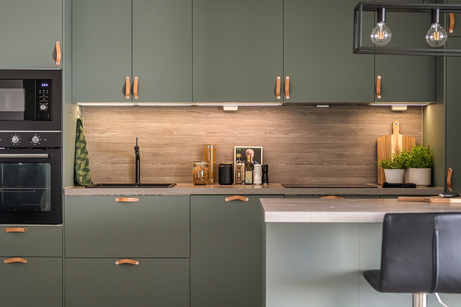 Kjøkkenet er utstyrt med integrerte hvitevarer som kjøl-/fryseskap, oppvaskmaskin, mikroovn, stekeovn og platetopp med kullfiltervifte over stekesonen Galleribilde