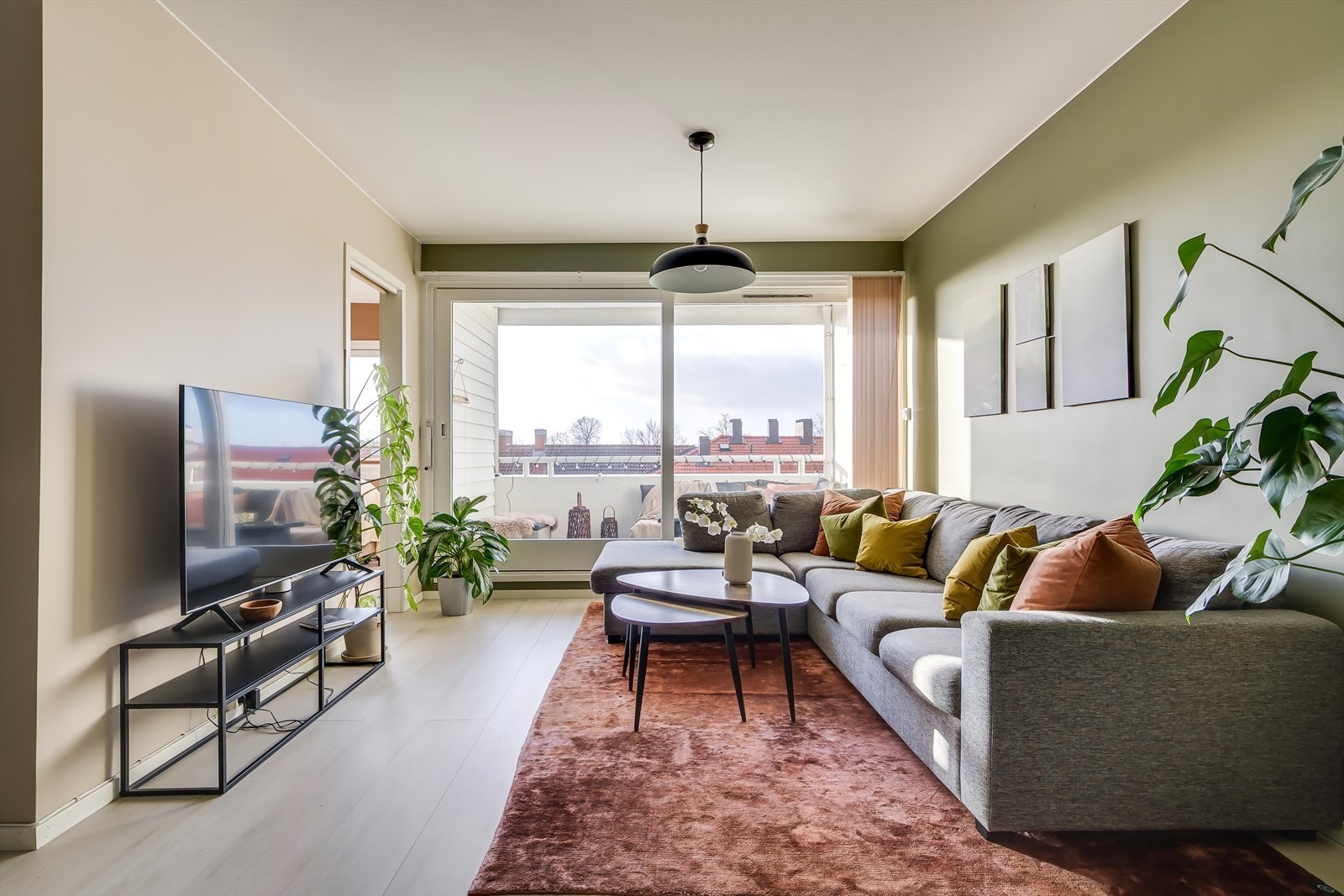 Den lyse og hyggelige stuen har store vindusflater som sikrer gode lysforhold og gir rommet en luftig atmosfære Galleribilde