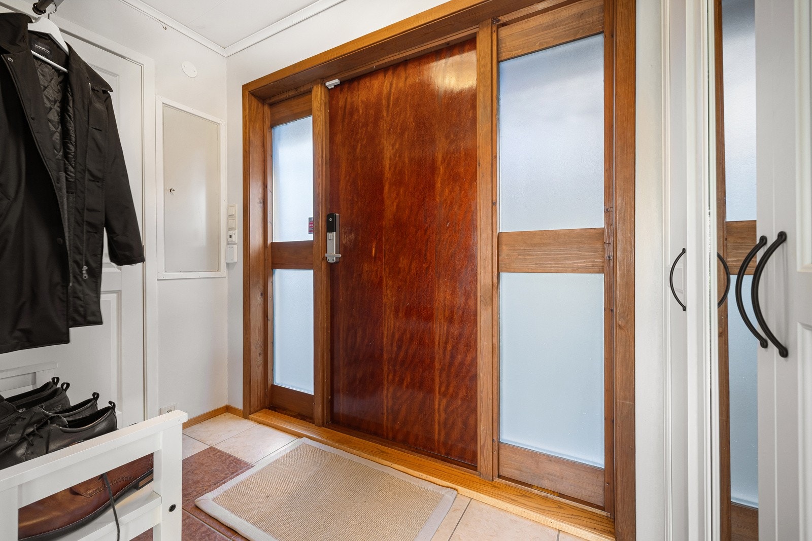 Flislagt entrè med god plass til yttertøy og sko Galleribilde