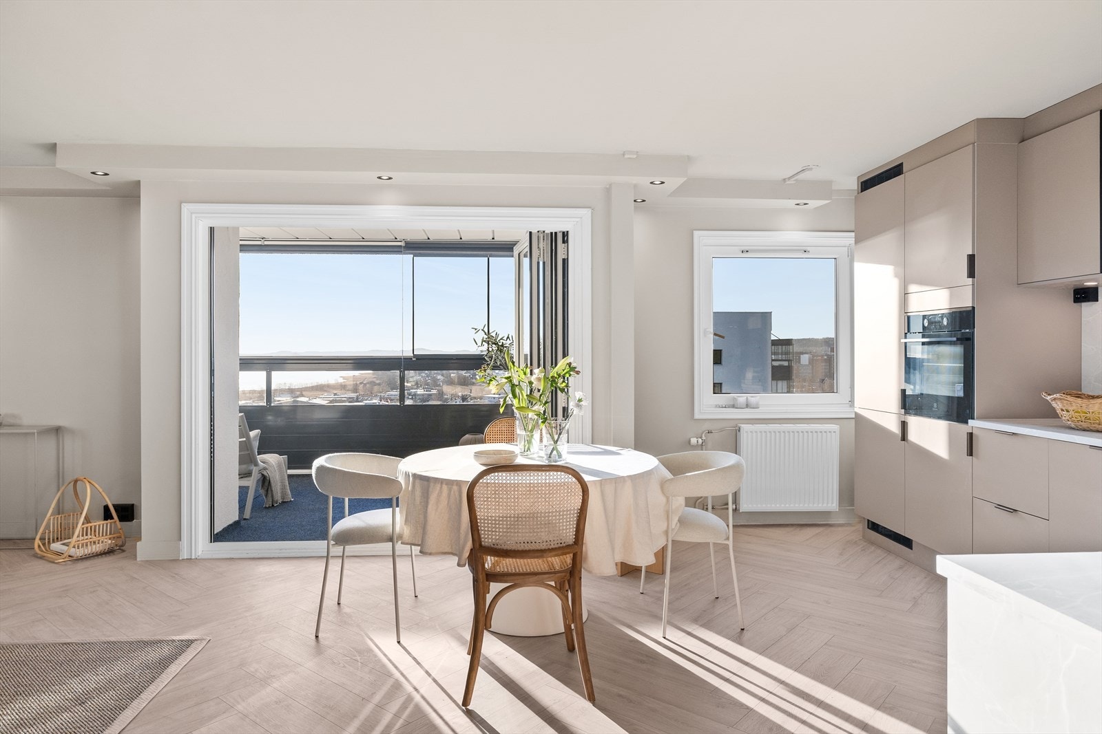 Store vindusflater og god takhøyde gjør rommet lyst og luftig, og det er god plass til spisebord i tilknytning til kjøkkensonen. Galleribilde