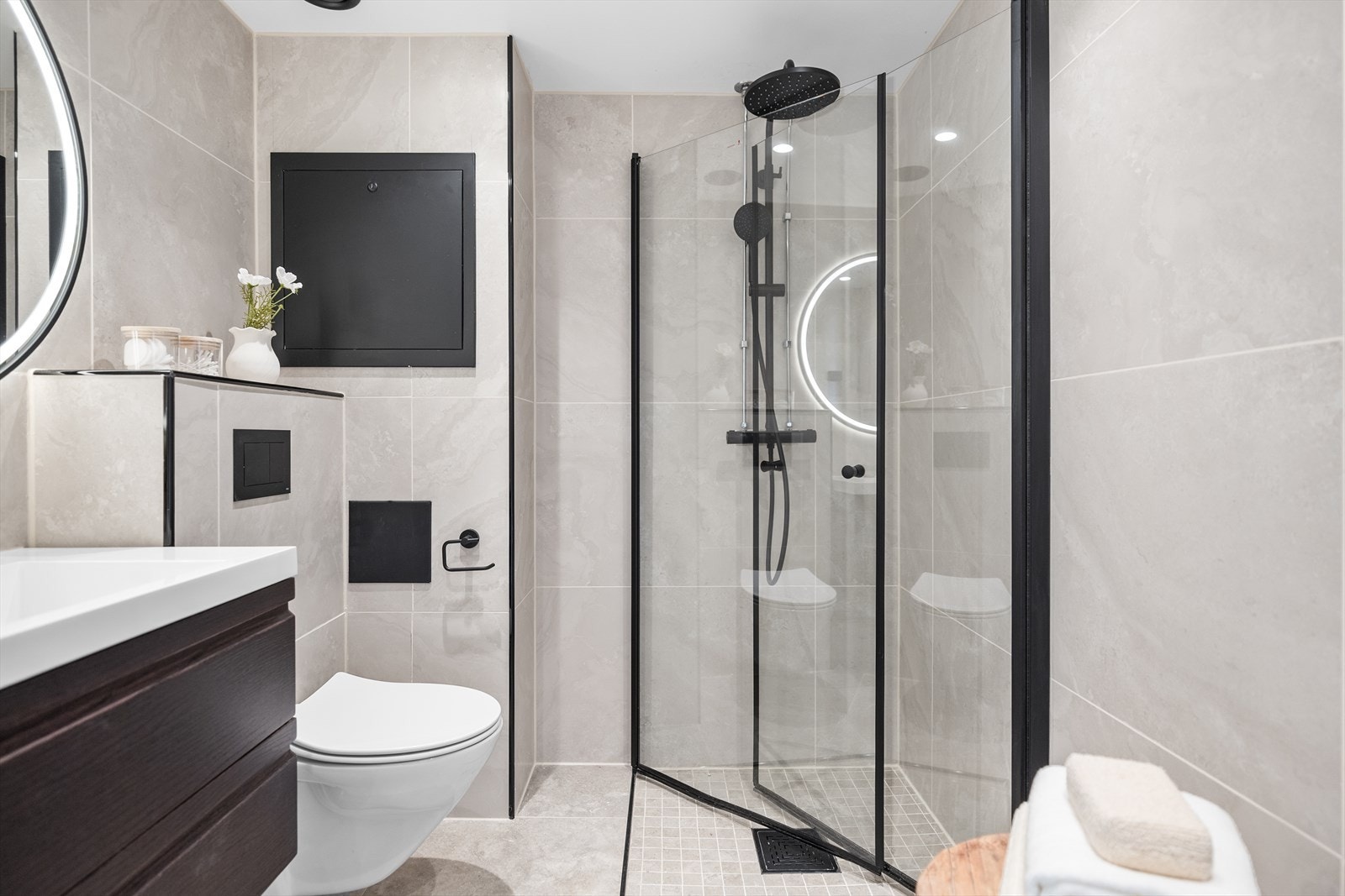 Badet fremstår som moderne og stilrent med gjennomgående lyse, store fliser som gir et eksklusivt uttrykk. Galleribilde