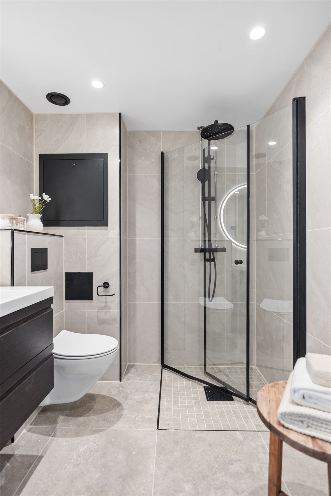 Dusjsonen har sorte detaljer, inkludert dusjgarnityr og innramming av de transparente dusjdørene, som gir et lekkert og tidsriktig kontrastpreg. Galleribilde