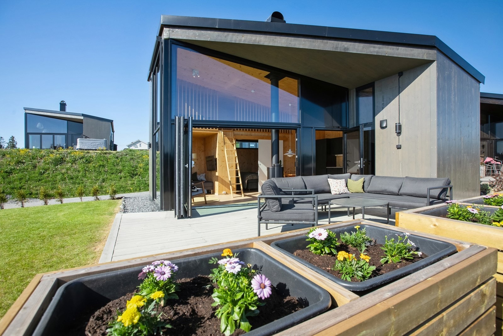 Her får du en stilfull og arealeffektiv hytte hvor hver kvadratmeter er utnyttet til perfeksjon. Store vindusflater slipper inn det naturlige lyset og gir en sømløs overgang mellom inne og ute. Galleribilde