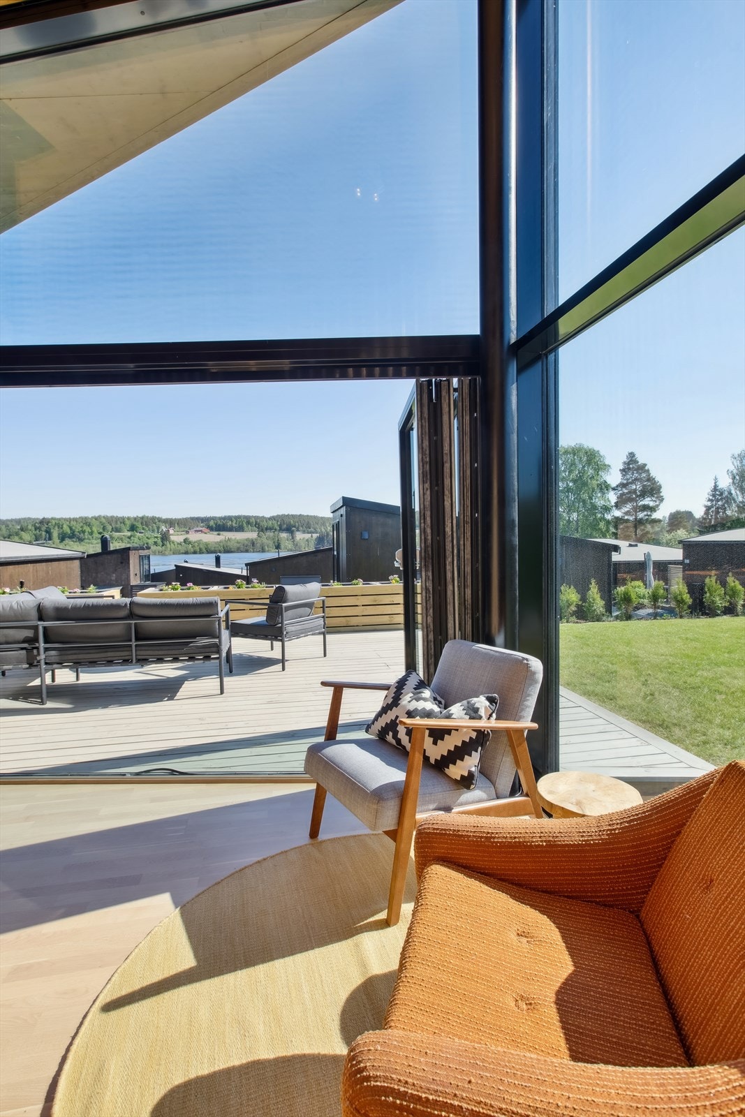 Store vindusflater som slipper naturen direkte inn i hytta. Praktisk foldedør som åpner opp mellom uterom og stue. Galleribilde