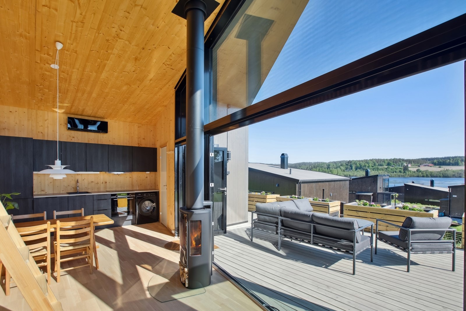 Hytta har moderne arkitektur med store vindusflater samt en unik skyvefoldedør i glass som skaper en utrolig opplevelse av å få naturen direkte inn i hytta. Galleribilde