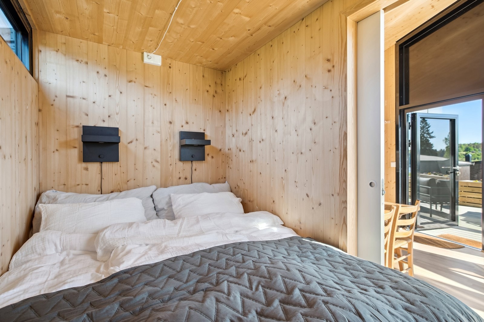 Hovedsoverom med foliert skyvedør og avlange vinduer som gir godt lysinnslipp gjennom rommet til stuen. Galleribilde