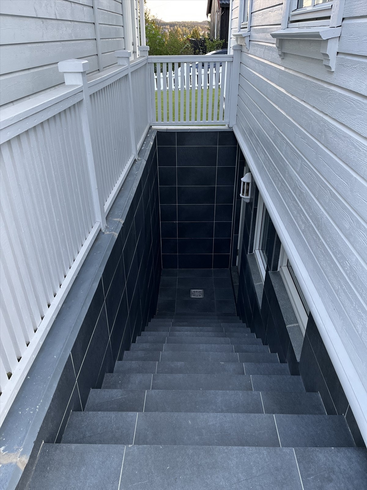 Trapp ned mellom garasjen og huset med inngangsdør til kjellerstue i utleiedel. Galleribilde