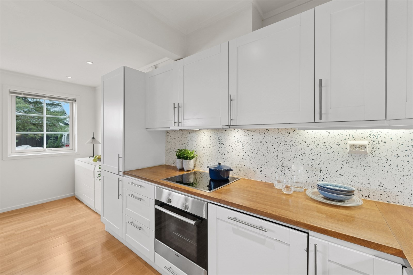 Lyse plater over benkeskapene, står i stil til kjøkkenet. Galleribilde