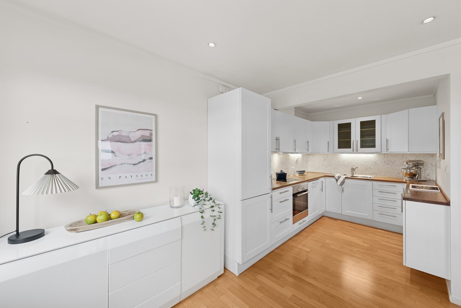 Klassisk, lyst kjøkken med profilerte fronter og integrerte hvitevarer. Galleribilde