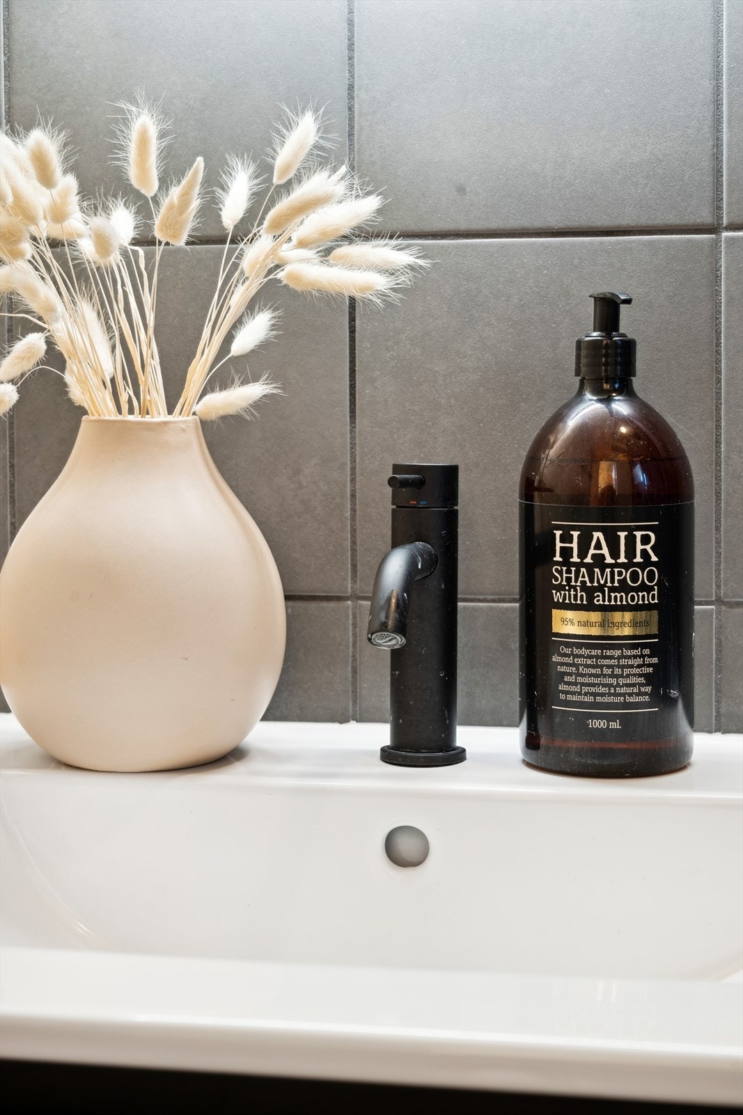 Badet har tidløse flisvalg og gjennomførte sorte detaljer. Galleribilde