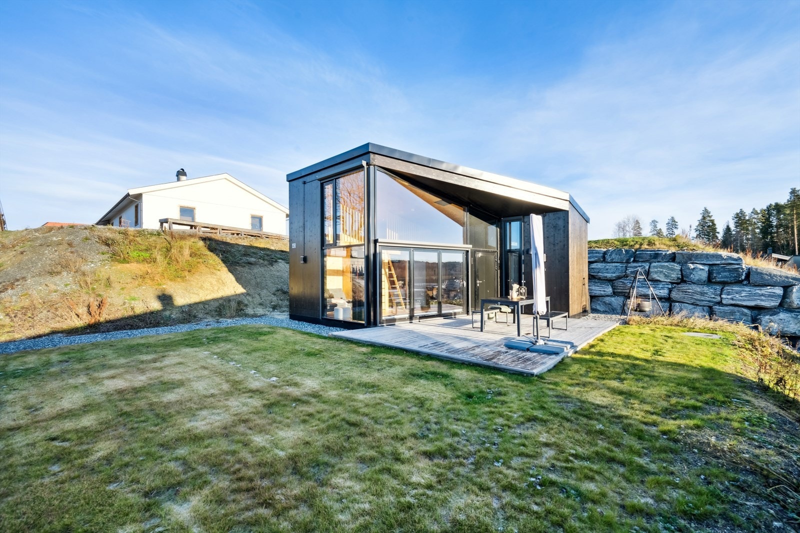 Strandhytta er en moderne og tidløs hyttemodell med en praktisk og arealeffektiv planløsning. Vinduene har praktisk solskjerming med screens og varmepumpe som gir en behagelig temperatur i hytta på vinterstid såvel som sval temperatur på varme dager. Galleribilde