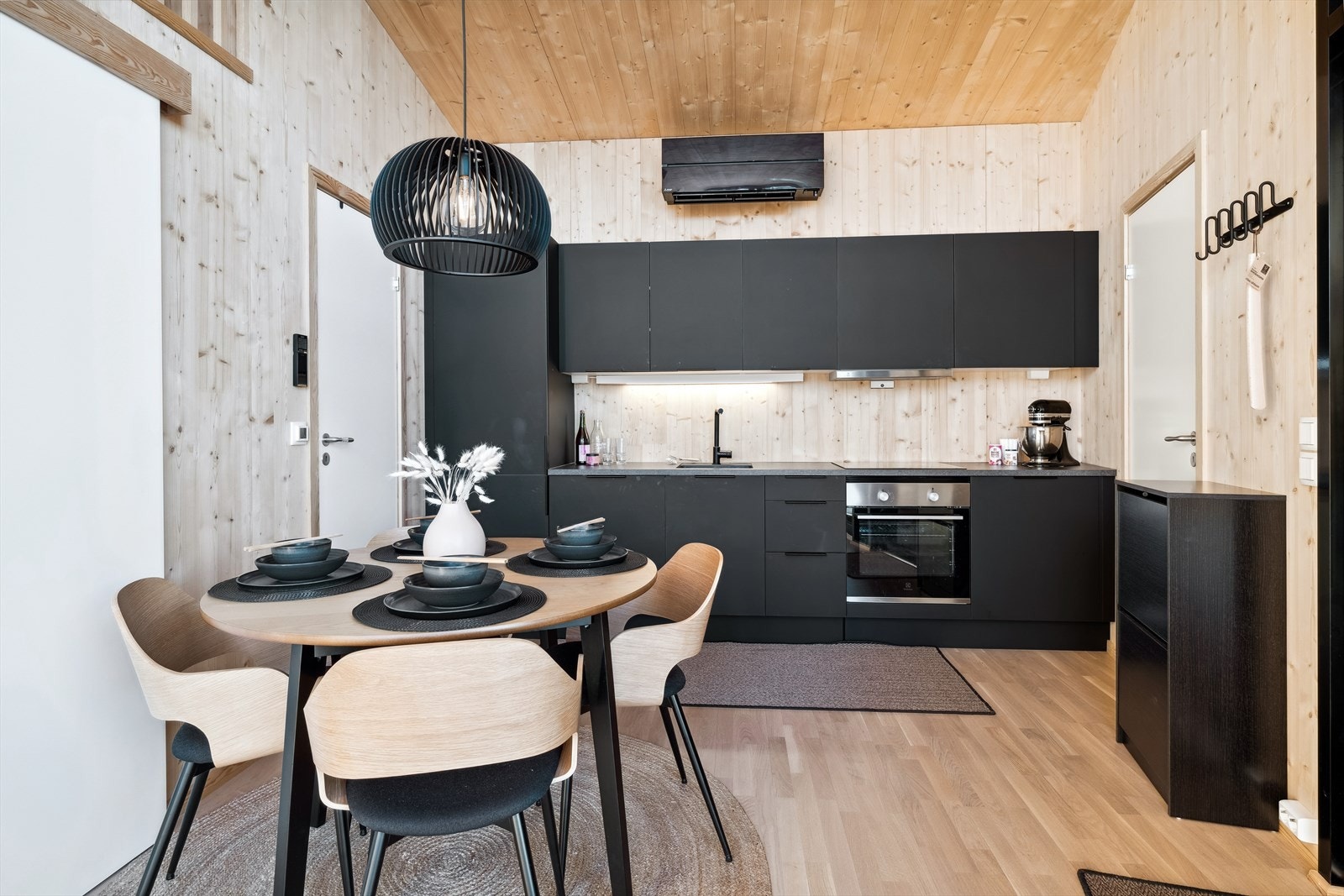 Flott HTH kjøkken med moderne sort innredning. Lys panelkledning hvor du kan sette ditt eget preg på interiør og farger. Galleribilde