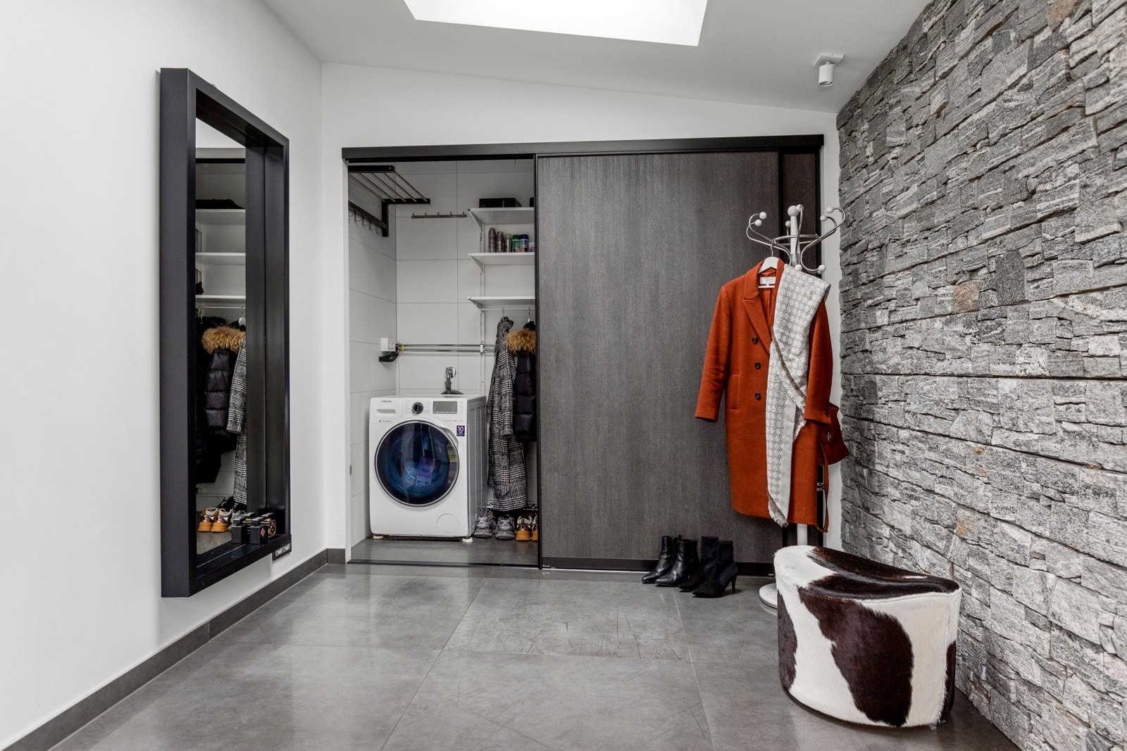 Stor hall med skyvedørsgarderobe som har nisje for vaskemaskin Galleribilde
