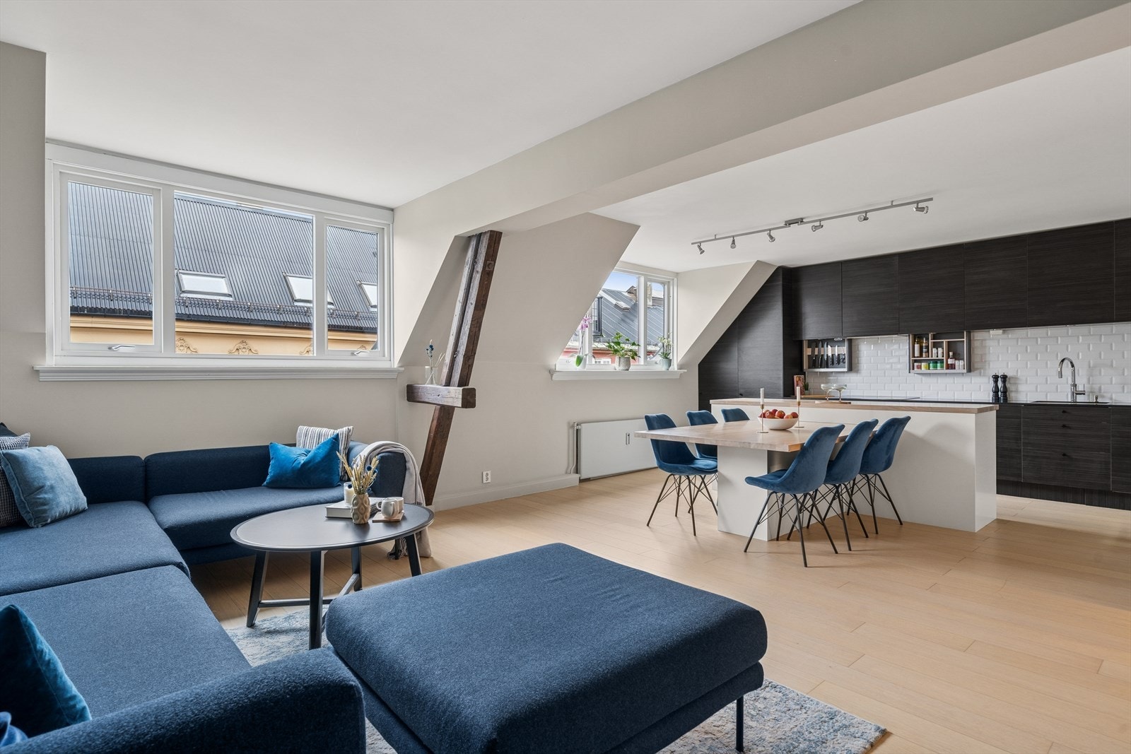 Stor møbleringsvennelig stue og kjøkken som er inndelt i flere ulike sosiale soner. Galleribilde