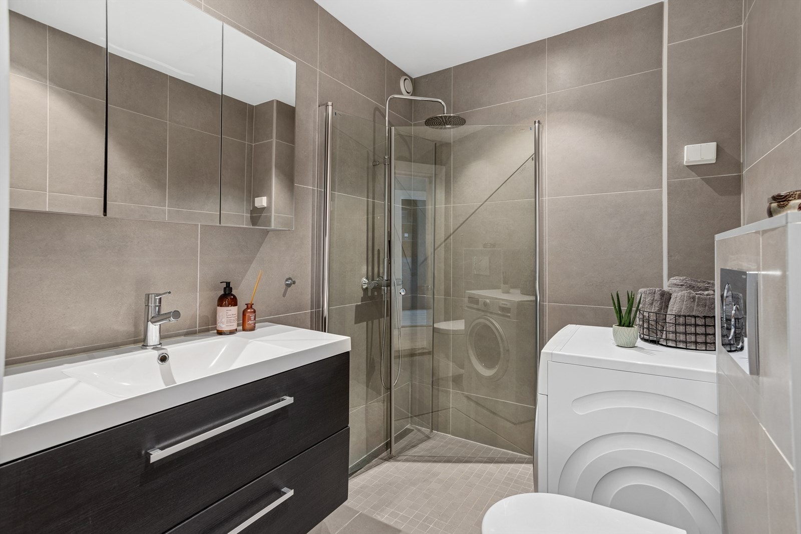 Delikat og tidløst flislagt baderom, oppusset i 2017. Det er downlights i himling, varmekabler i gulvet, opplegg for vaskemaskin og plass til tørketrommel. Galleribilde