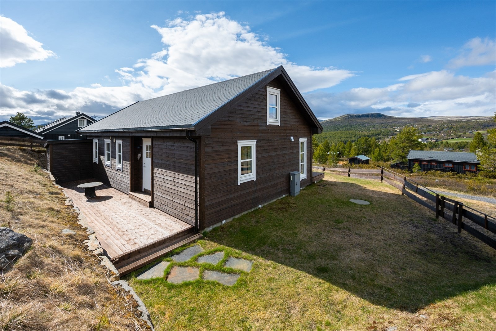 Tomten er pent opparbeidet med plen, belegningsstein og støttemur av naturstein. Det er anlagt markterrasse på begge sider av hytta. Galleribilde