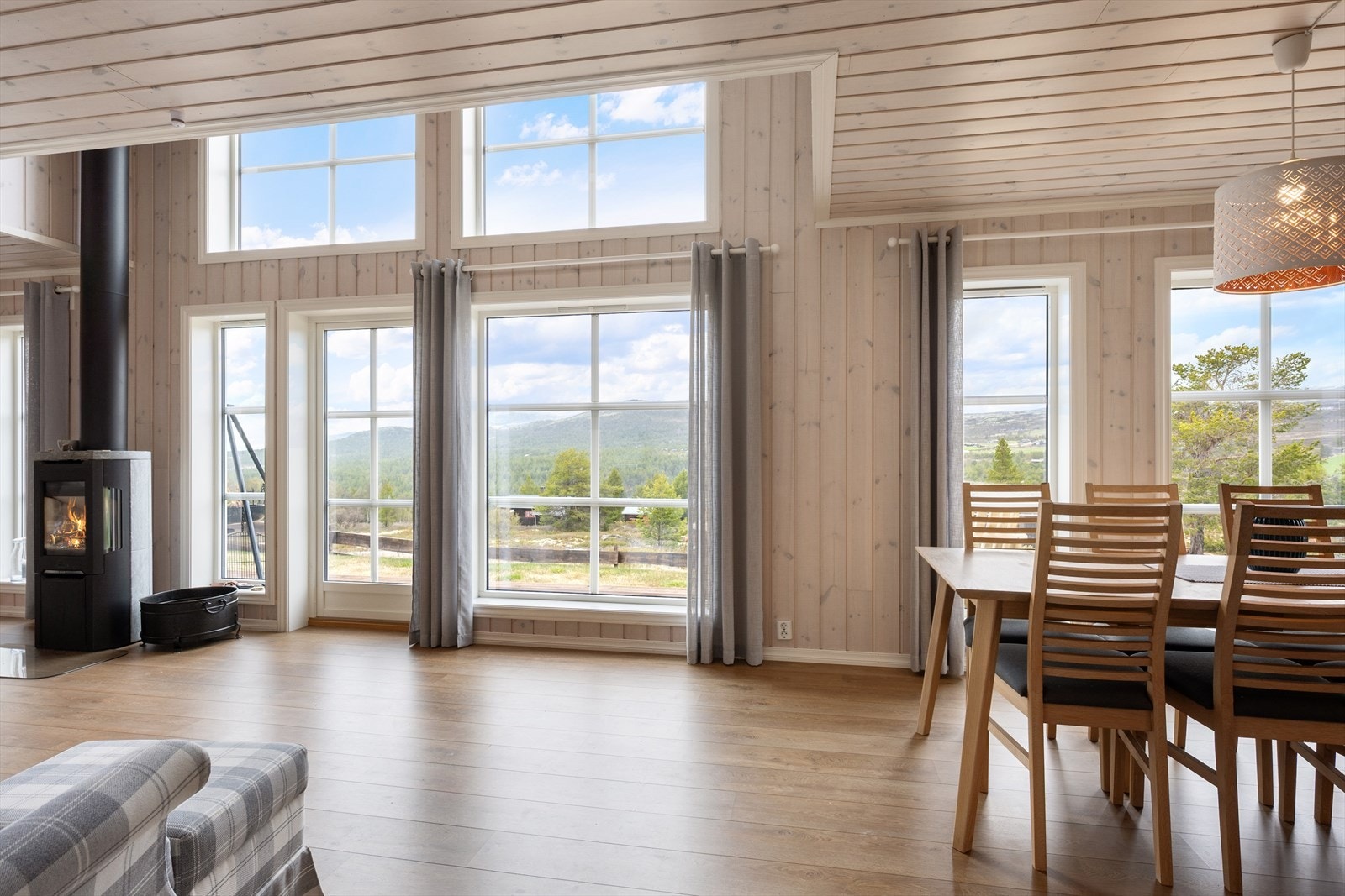 Du kommer inn i en lys og trivelig stue med store vindusflater som slipper inn rikelig men naturlig lys. Galleribilde