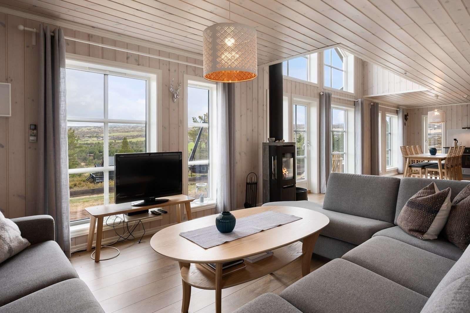 Trivelig sofakrok foran peisovnen med flott utsikt. Galleribilde