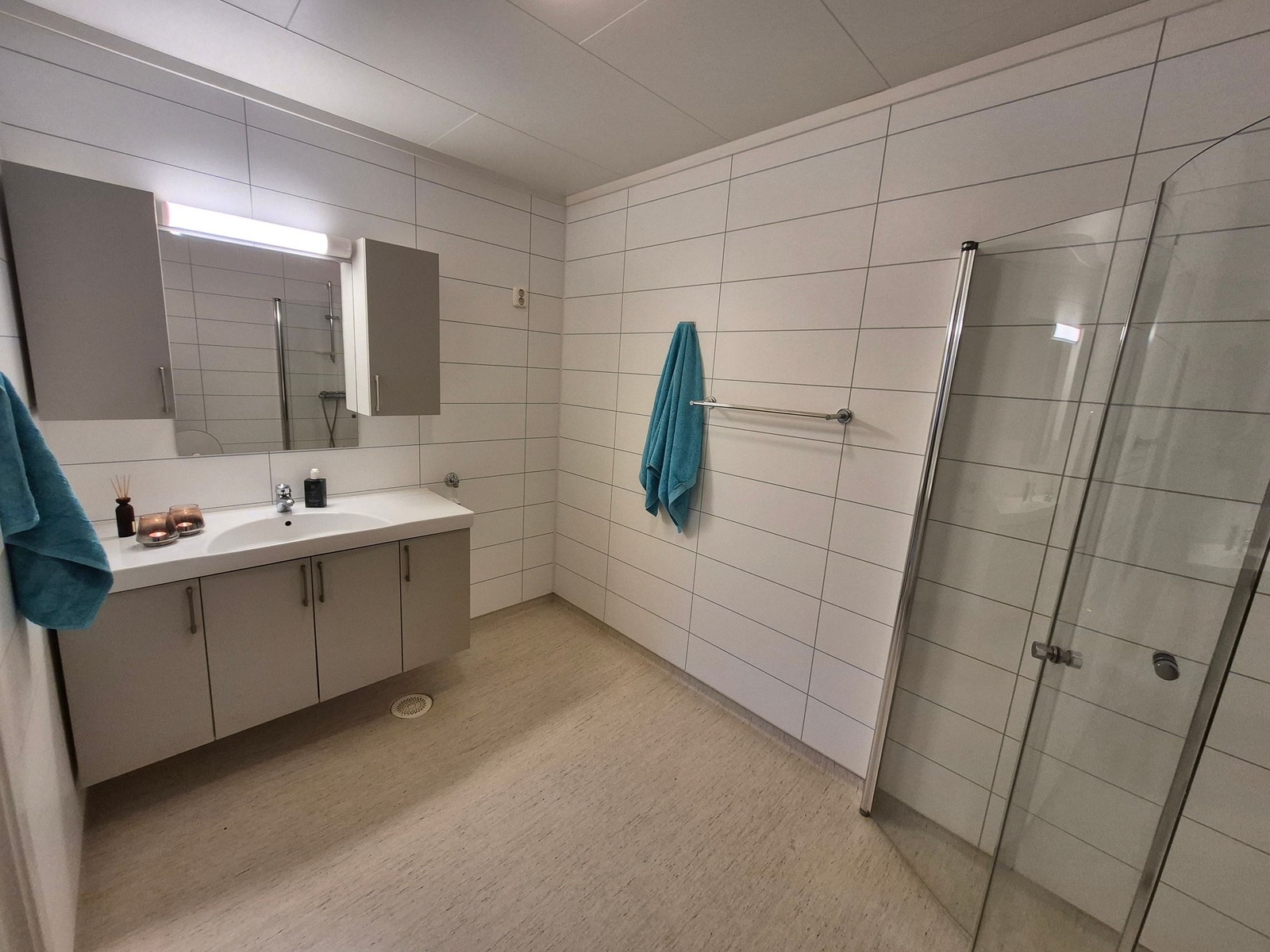 Bad med dusjdører, greit med oppbevaringsplass i baderomsinnredningen og lagt opp for vaskemaskin. Galleribilde