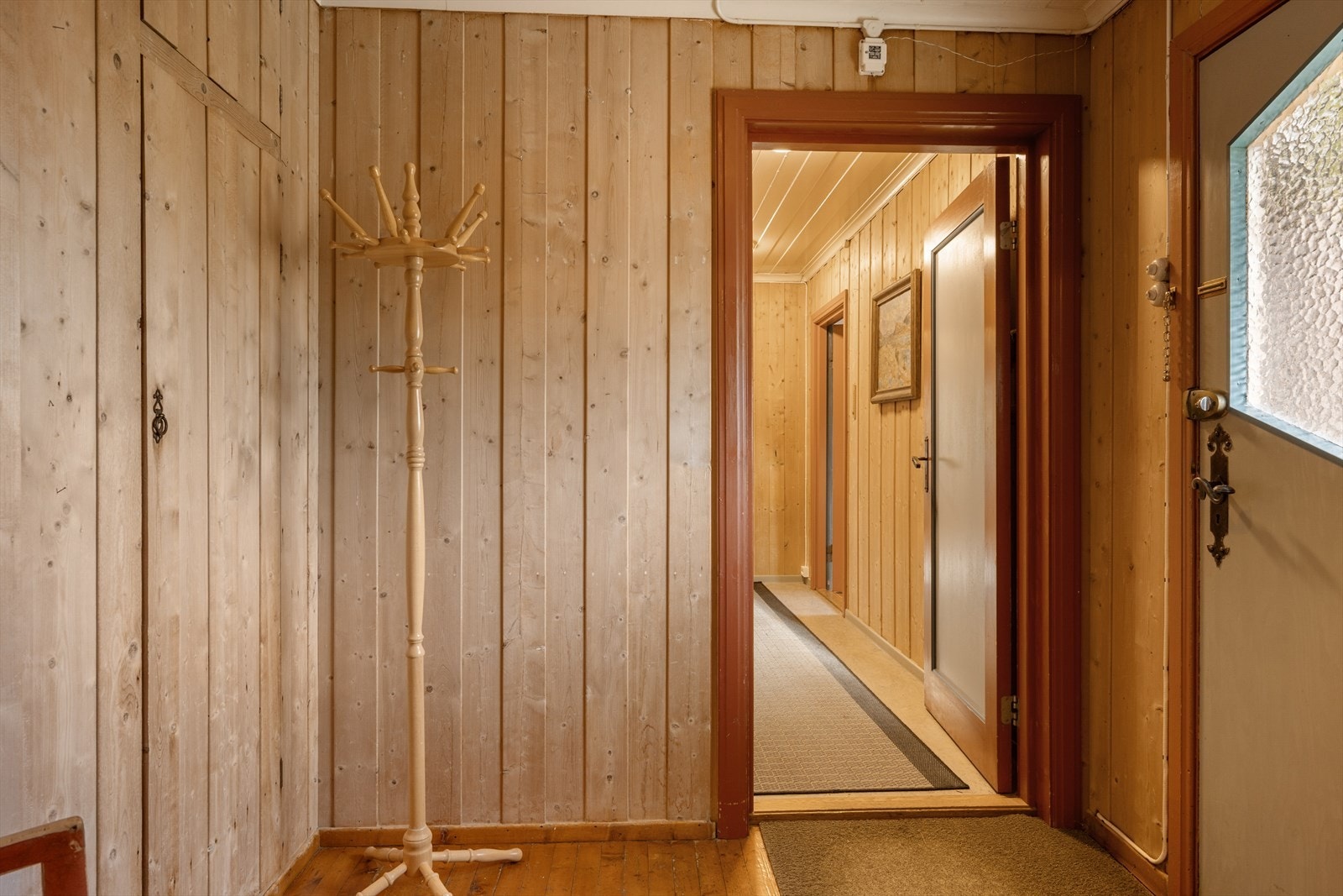 Plassbygd garderobeskap i entréen gir praktisk oppbevaring av yttertøy og sko. Galleribilde