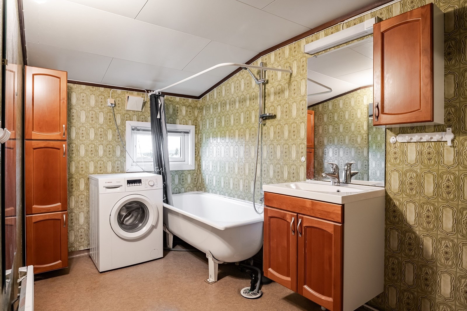 Badet i andre etasje er av eldre dato og er innredet med badekar, servant nedfelt i innredning flere skap, opplegg for vaskemaskin og frittstående toalett. Galleribilde