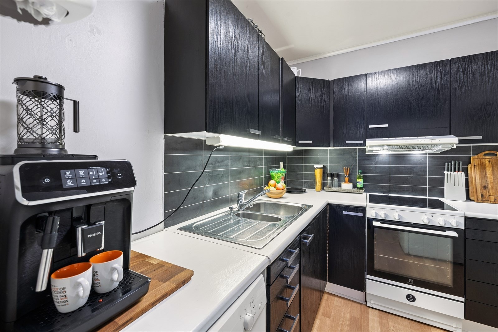 Kjøkkenet har innredning med glatte fronter med folie og benkeplate av laminat og tre. Galleribilde