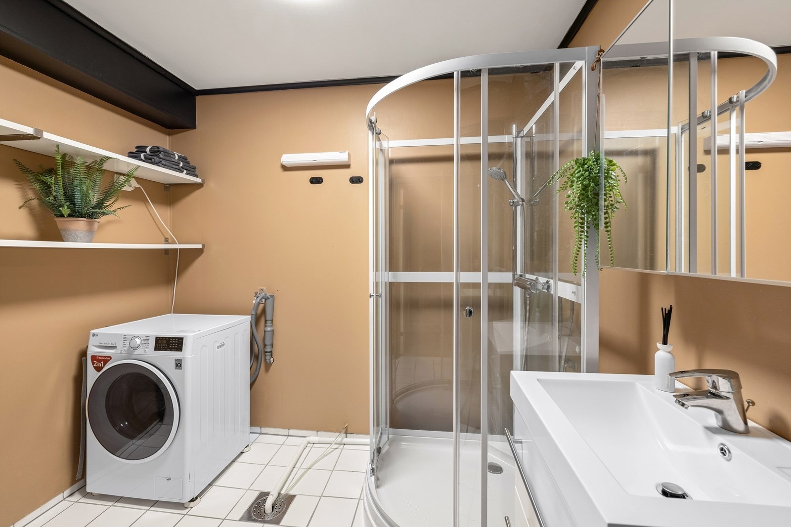 Bad med baderomsplater på veggene og fliser på gulv med gulvvarme. Galleribilde