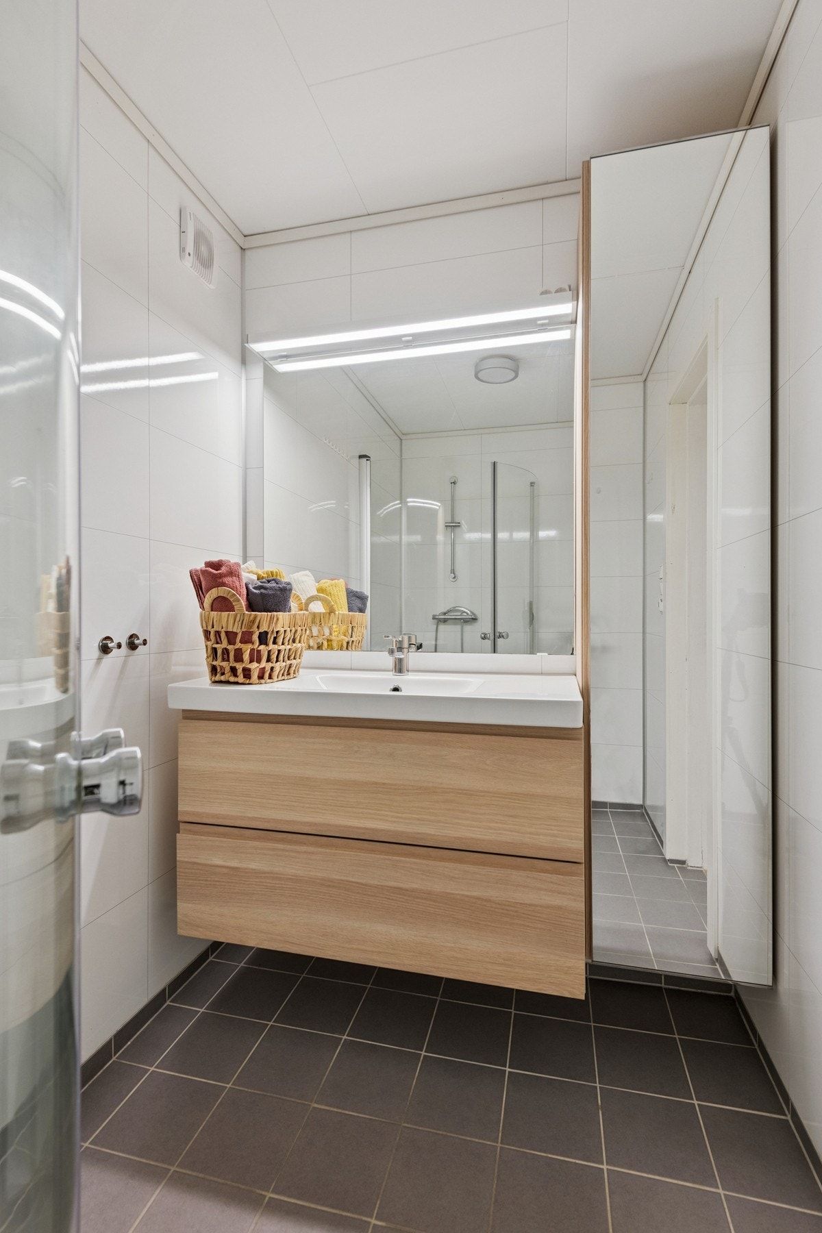 Flislagt gulv med varmekabler. Dusjhjørne og romslig baderomsinnredning. Galleribilde