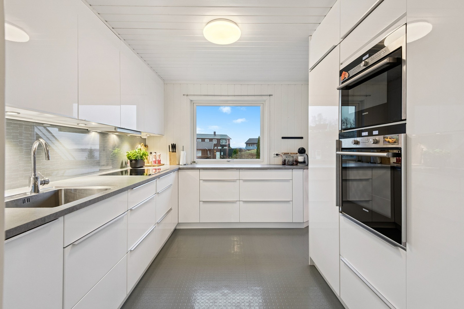 Pent og moderne kjøkken med integrerte hvitevarer i hoveddel. Galleribilde