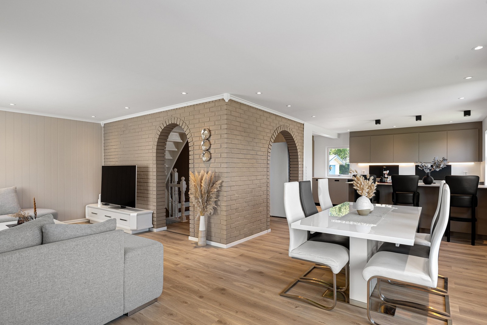 Lys og innbydende stue med åpen løsning mot kjøkken - en sosial og romslig sone med god plass til både tv-krok og spisebord. Galleribilde