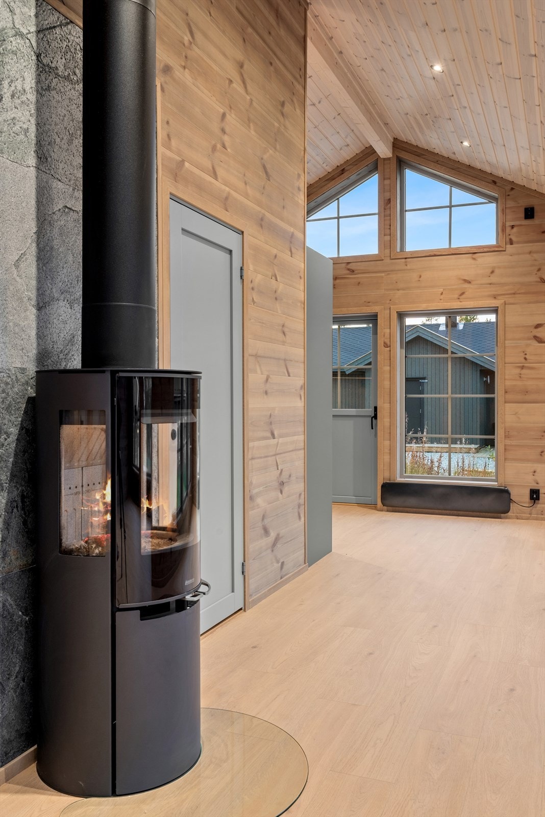 Etter en lang dag ute kan man komme inn å varme seg foran en peisovn, sentralt plassert på stuen. Galleribilde