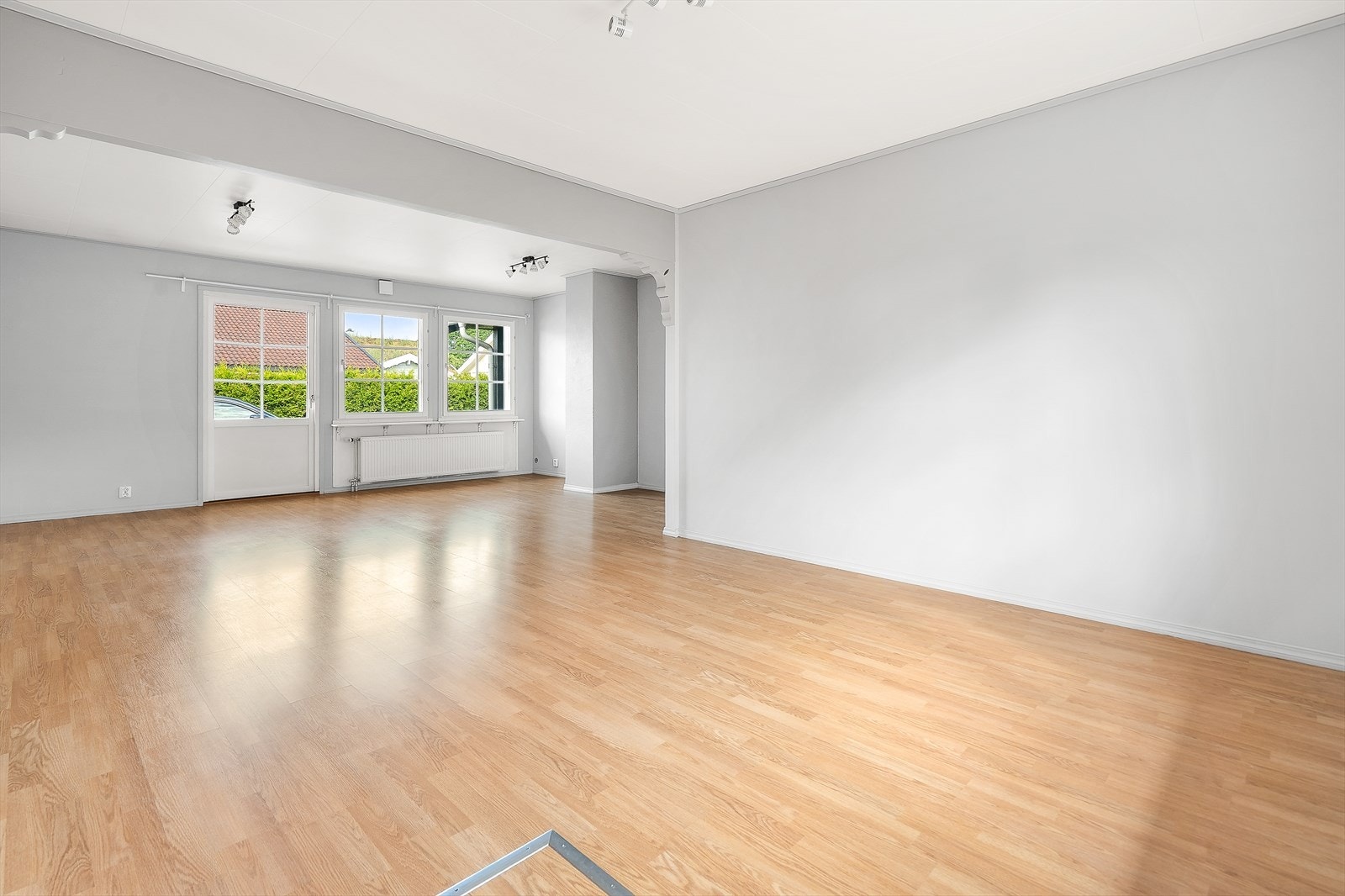 Stuen har flere vinduer og utgang til hage, noe som gir en luftig og innbydende atmosfære. Galleribilde