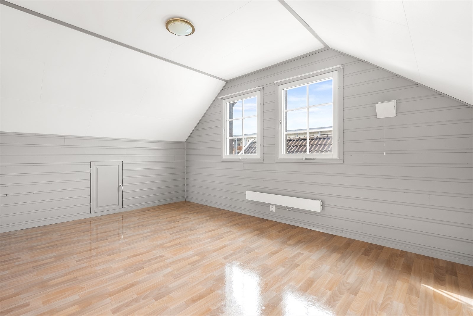 Lyst soverom i andre etasje med radiator og tilkomst til praktiske lagringsmuligheter på kneloft. Galleribilde
