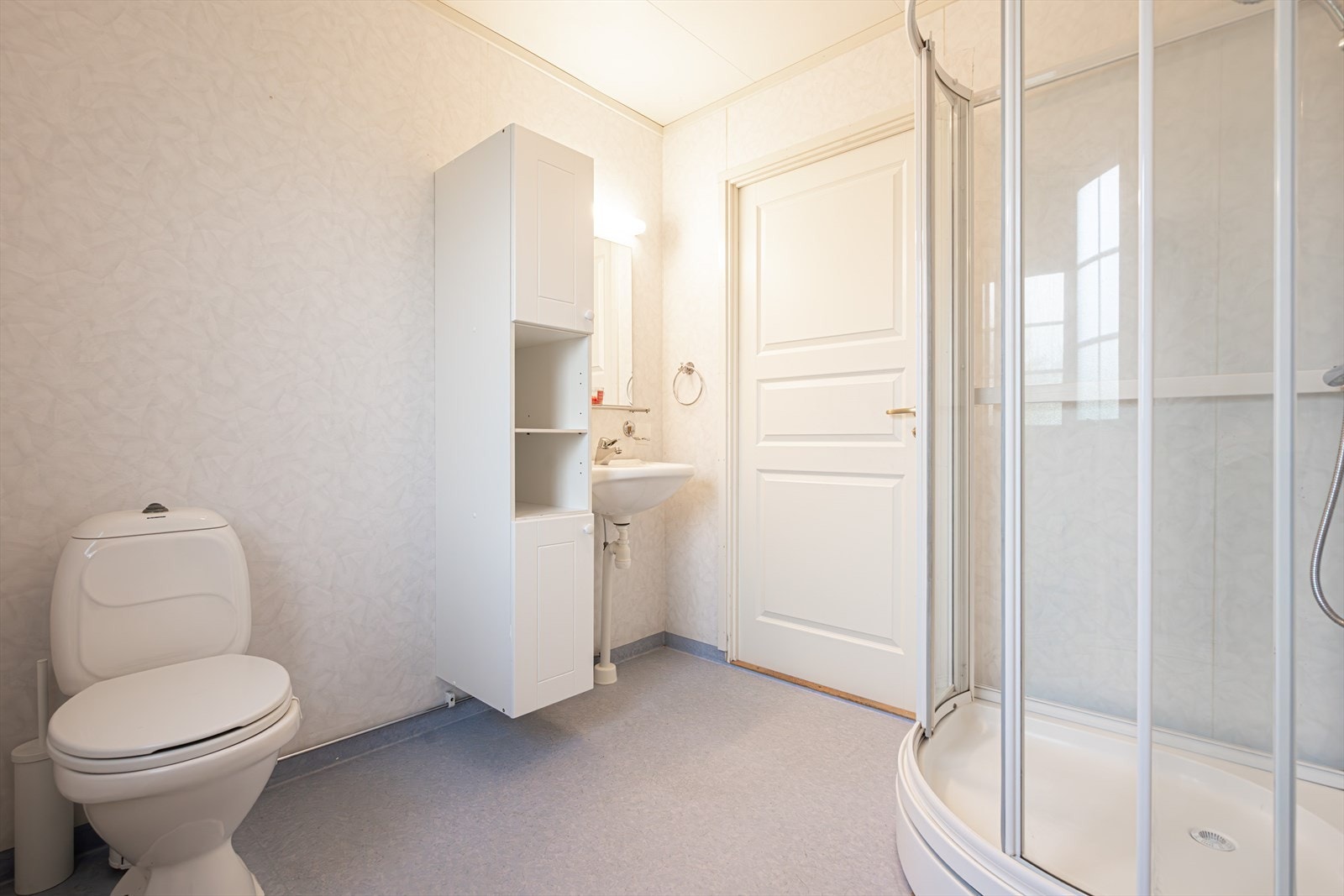 Badet har varmekabler, dusjkabinett og opplegg for vaskemaskin - alt samlet for hverdagskomfort. Galleribilde