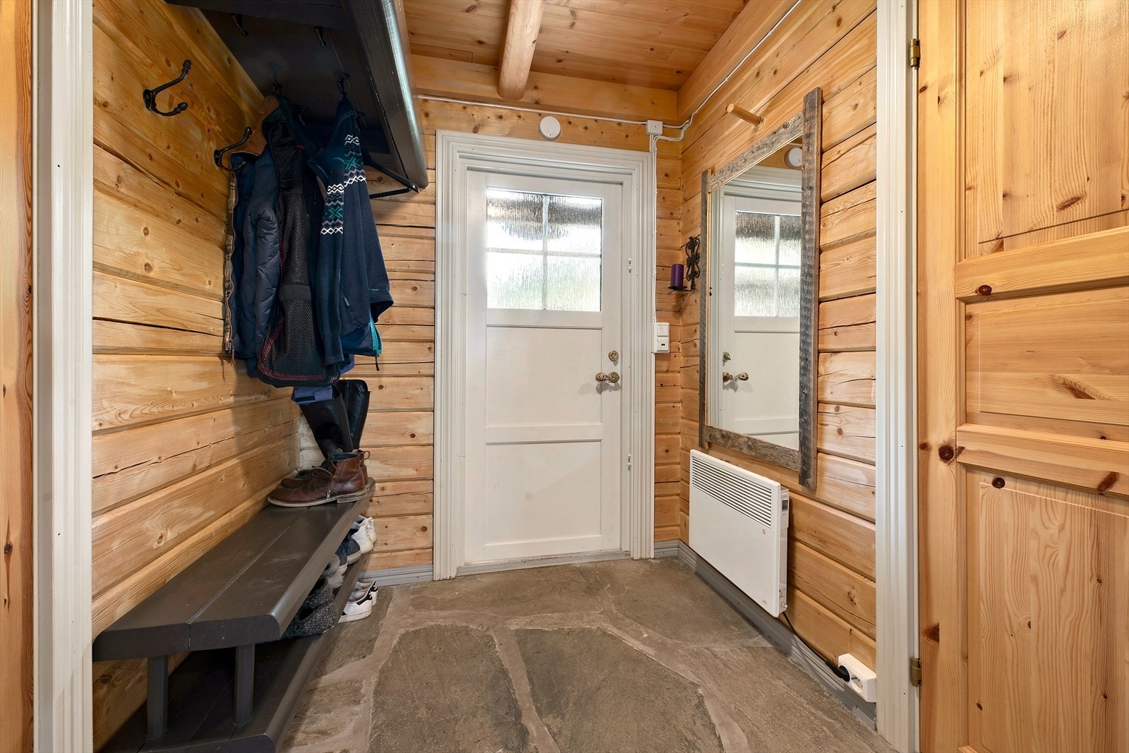 Velkommen inn i en hytte med en helhetlig og meget koselig stil. I gangen er det skifergulv med gulvvarme. Galleribilde