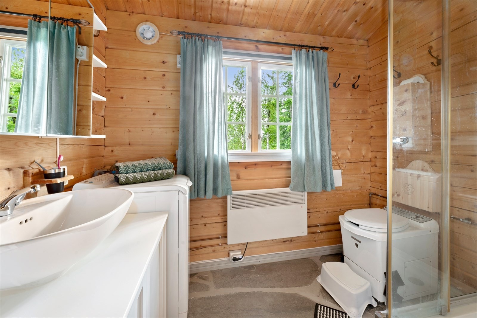 Bad/vaskerom/badstu har samme flotte skiftergulvet som i gangen. Gulvvarme. Forbrenningstoalett, dusjkabinett, servant med speilskap over. Vaskemaskin medfølger. Galleribilde