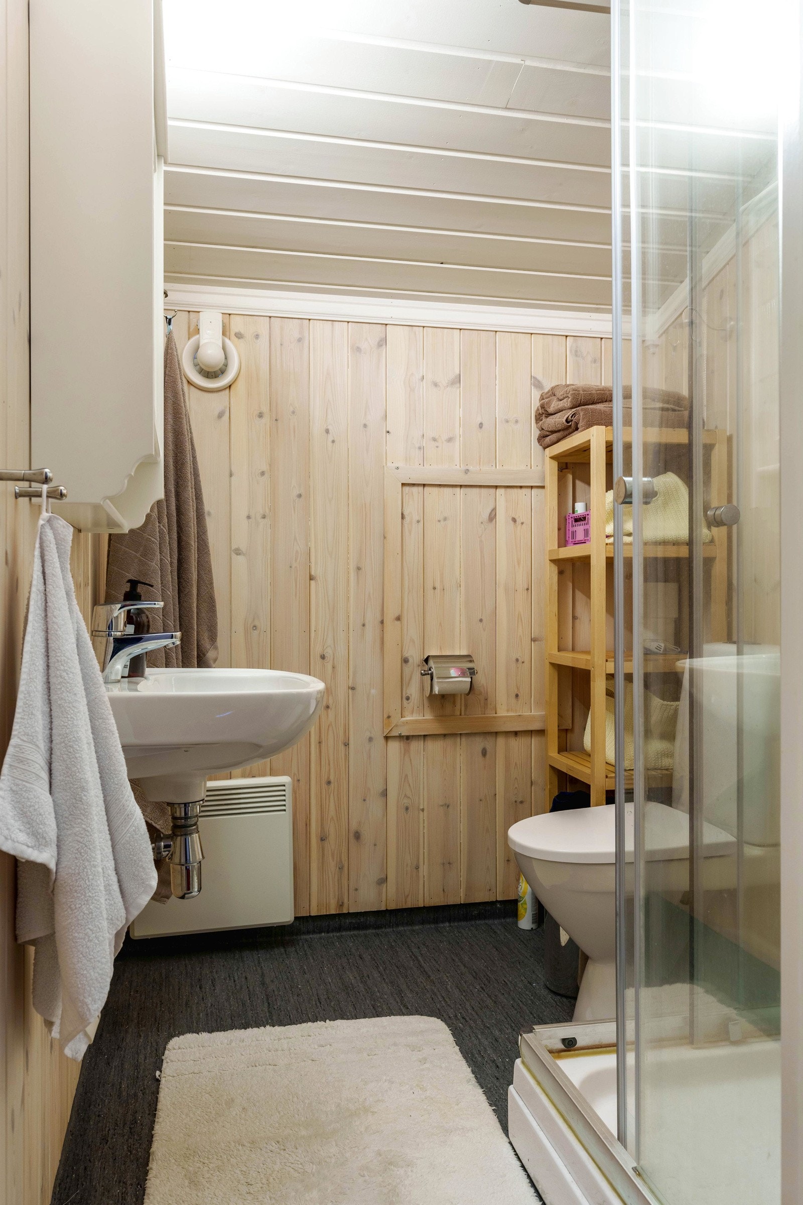 Hytta har også et bad i andre etasje med belegg på gulv og panel behandlet med panellakk på vegger og himling. Badet er innredet med dusjkabinett, klosett og servant. Galleribilde