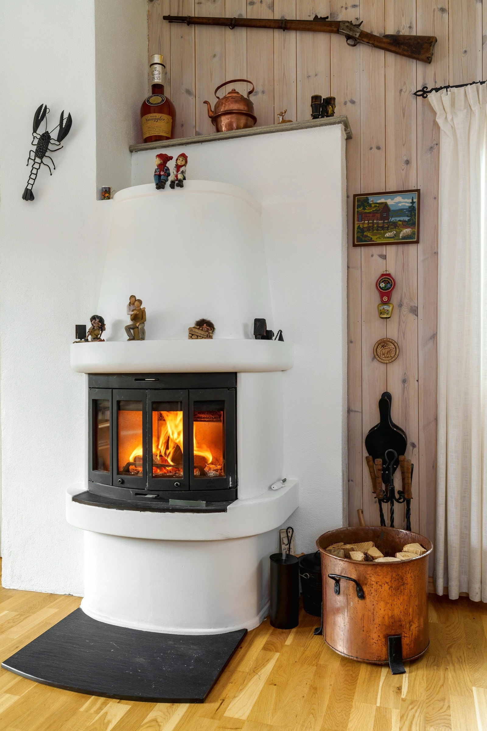 I stuen er det en flott elementpeis med innsats med dører, som effektivt varmer opp hytta. Galleribilde
