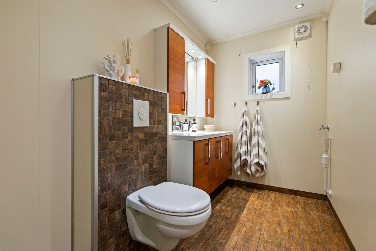 Via gangen har du inngang til baderom. Badet fremstår som moderne og funksjonelt med flislagt gulv med varme og våtromsplater på veggene. Galleribilde