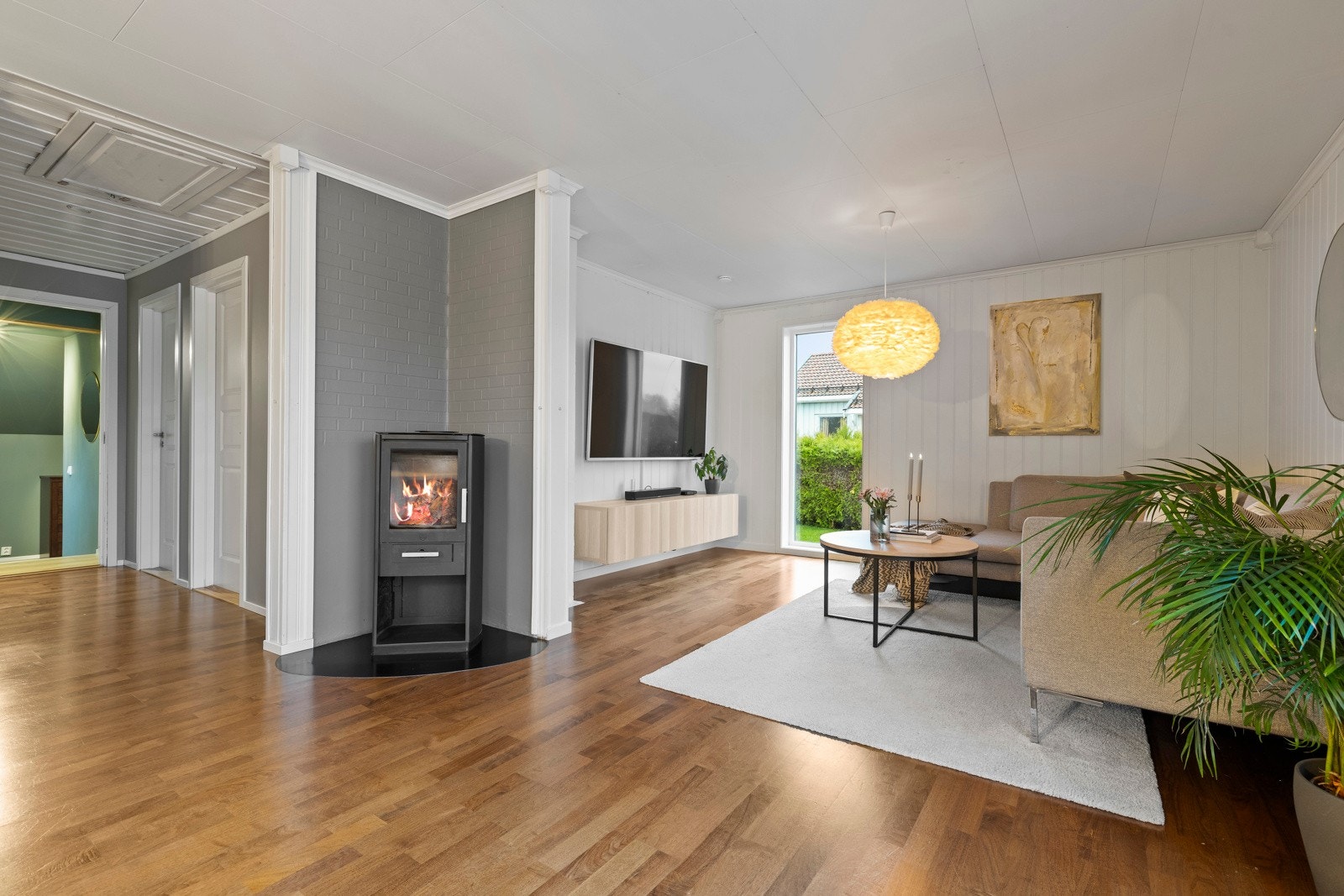 Vi beveger oss videre innover i boligen og møtes av den romslige stuen, et naturlig samlingspunkt for familie og venner. Galleribilde