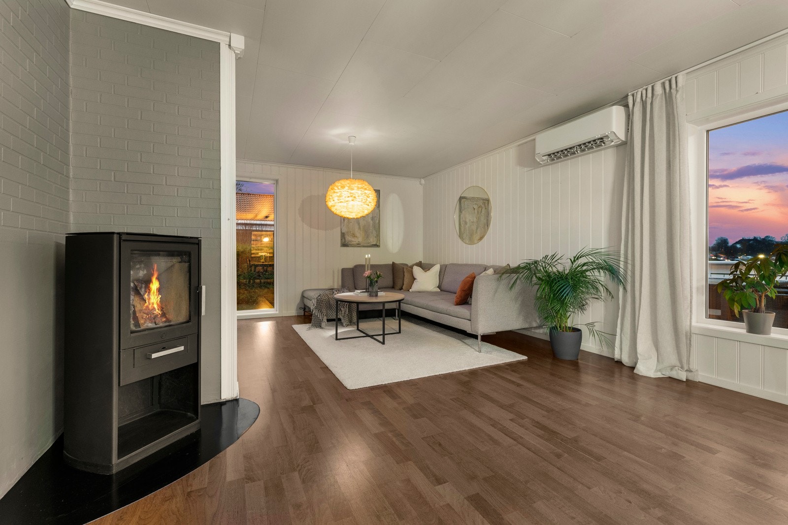 Peisen bidrar med lun varme og hyggelig atmosfære på kalde dager, samtidig som den fungerer som et naturlig skille mellom stuen og spisestue/kjøkken. Galleribilde