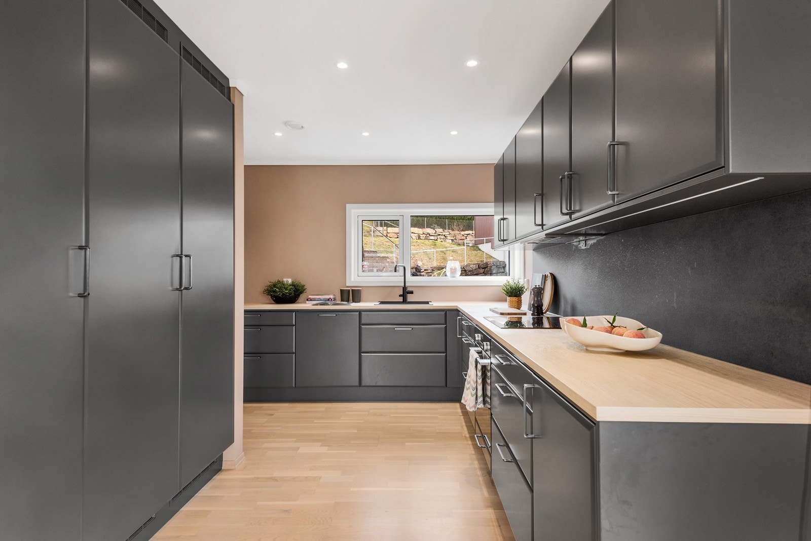 Kjøkkenet har en delvis åpen løsning mot stuen og byr på rikelig med både benke- og oppbevaringsplass. Galleribilde