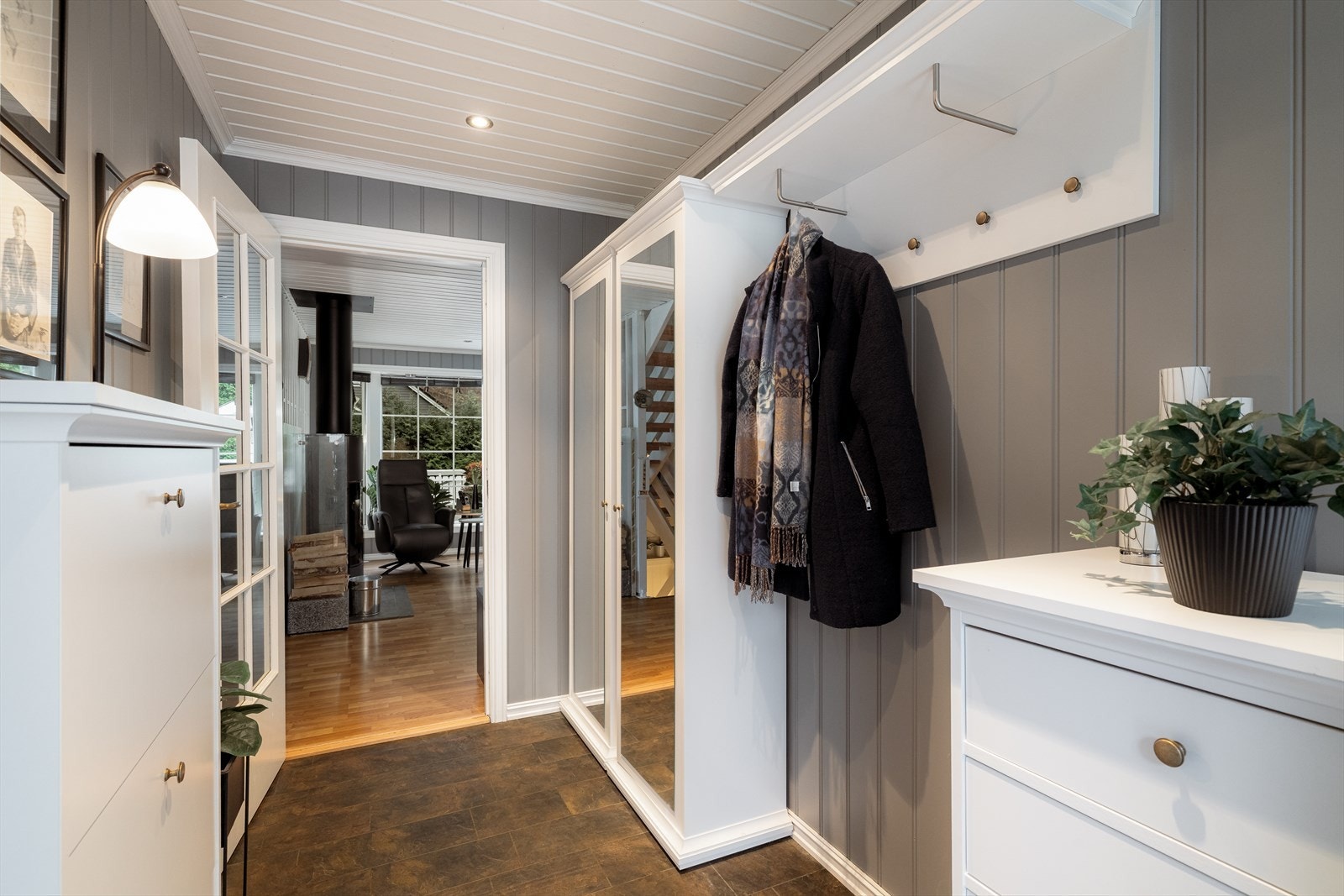 Gang med glassdør inn mot stua og god plass til klesoppbevaring på fastmontert garderobeløsning, samt i garderobeskap med speildører. Galleribilde